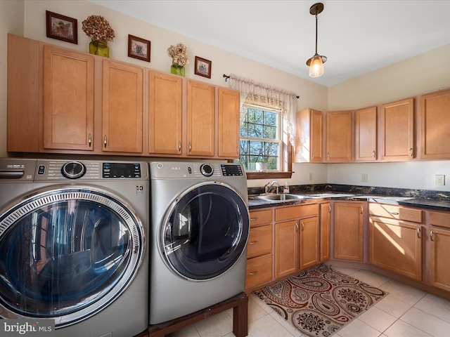 laundry area featuring light tile patterned floors, laundry area, a sink, and washer and clothes dryer