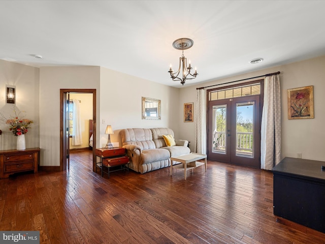 living room with baseboards, an inviting chandelier, french doors, and dark wood-type flooring