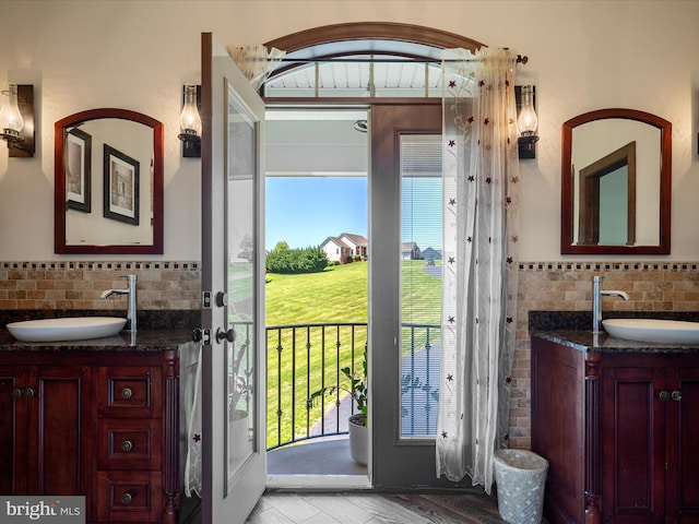bathroom featuring a sink, two vanities, and a wealth of natural light