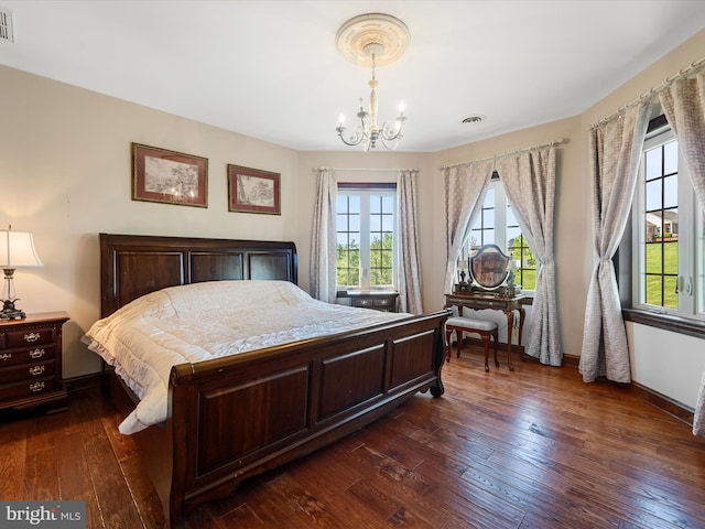 bedroom featuring an inviting chandelier, dark wood-style flooring, baseboards, and visible vents