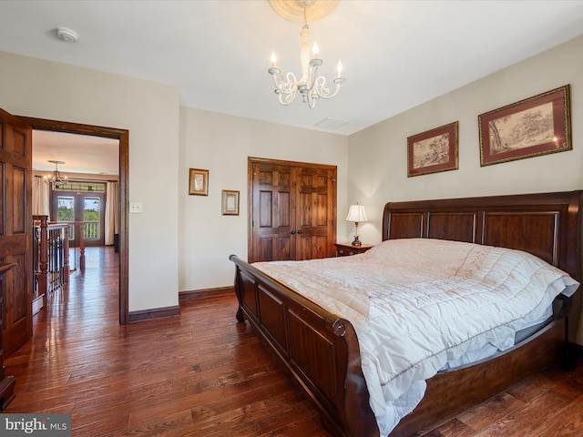bedroom featuring baseboards, an inviting chandelier, visible vents, and dark wood-type flooring