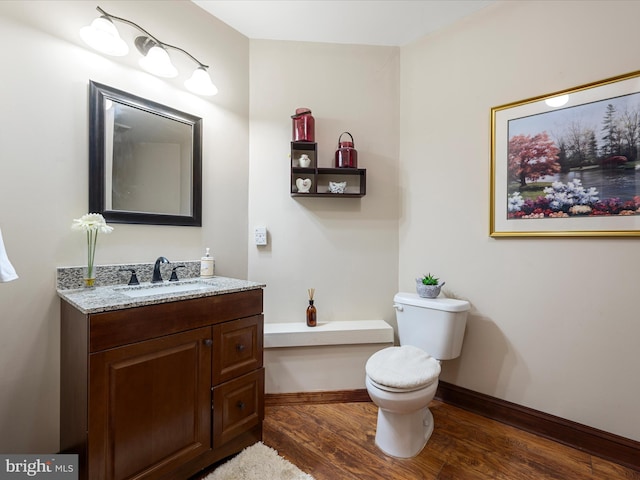 bathroom with vanity, baseboards, toilet, and wood finished floors