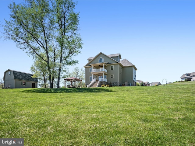 back of property with a yard and a gazebo