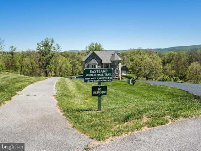 community sign with a lawn and a forest view