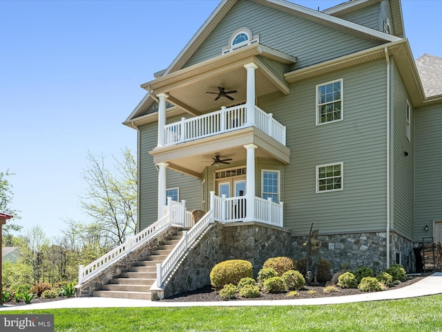 view of front of property with covered porch, a ceiling fan, a balcony, and stairs