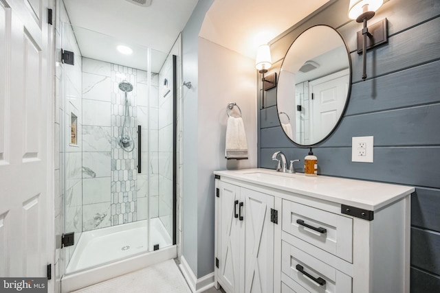 bathroom featuring a shower with door and vanity