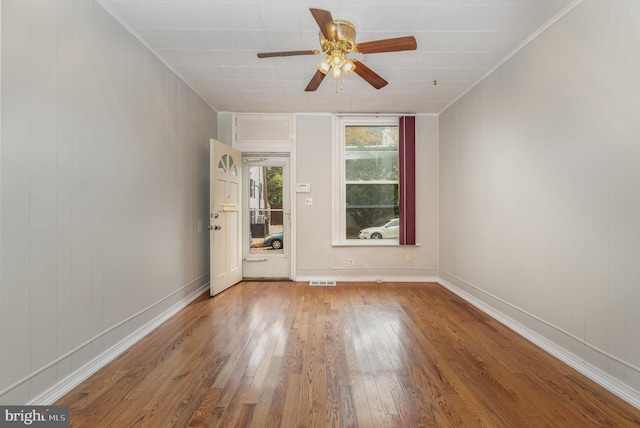 spare room with ceiling fan, wood-type flooring, and ornamental molding