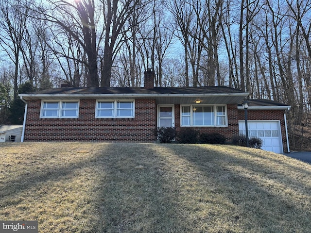 single story home with a front lawn, an attached garage, brick siding, and a chimney