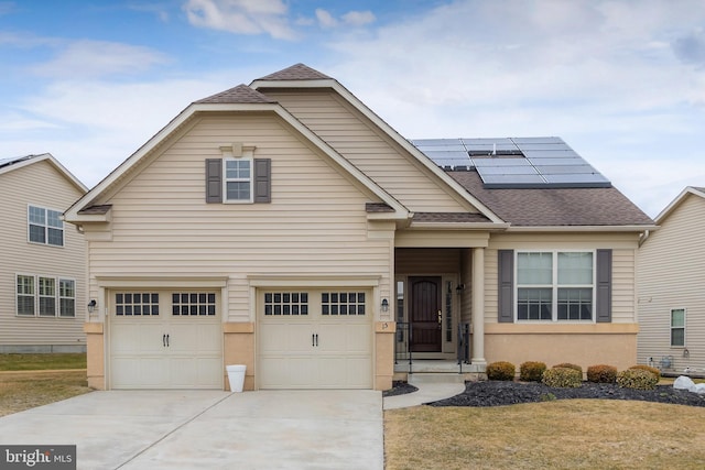 view of front facade with a garage, solar panels, a shingled roof, driveway, and a front yard