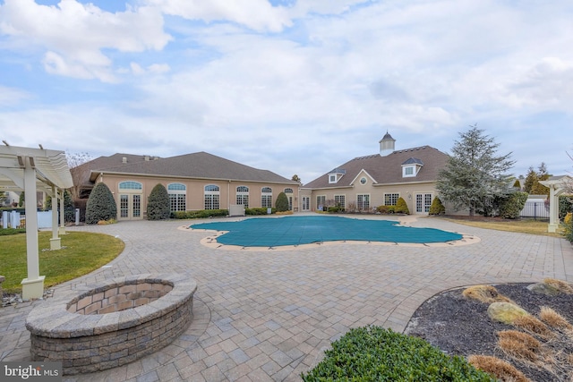 view of pool with a patio area, an outdoor fire pit, a fenced in pool, and french doors