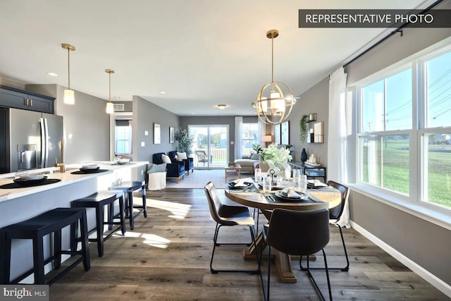 dining room with dark hardwood / wood-style flooring and a chandelier