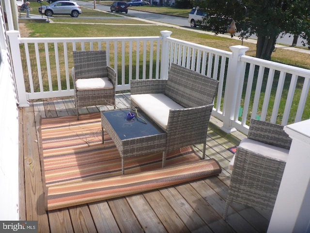 wooden terrace with a yard and an outdoor living space