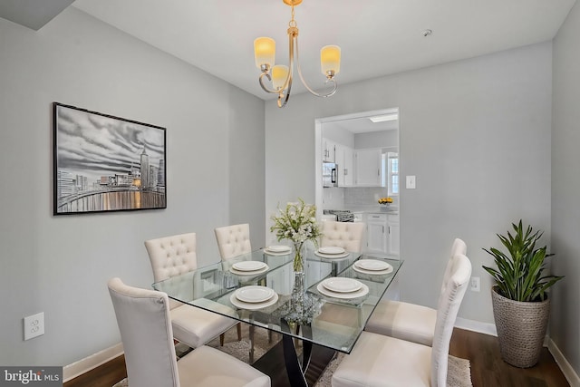 dining area featuring an inviting chandelier and dark hardwood / wood-style flooring