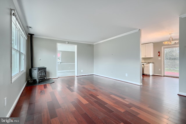 unfurnished living room featuring a wood stove, dark wood-type flooring, and crown molding