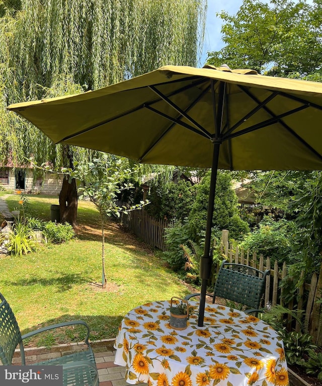 exterior space featuring fence, outdoor dining area, and a yard