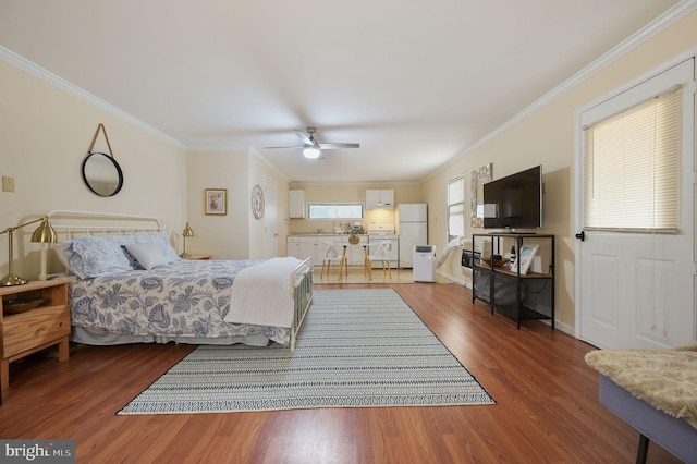 bedroom with ceiling fan, crown molding, white refrigerator, and hardwood / wood-style floors