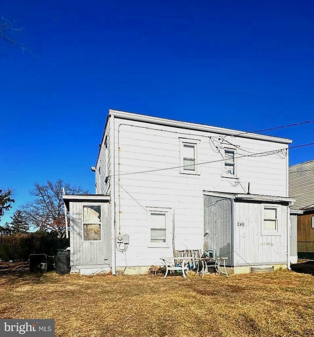 rear view of property featuring a lawn