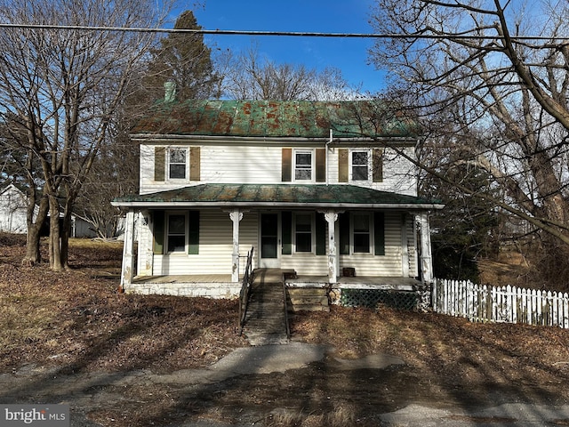 view of front facade featuring covered porch and fence