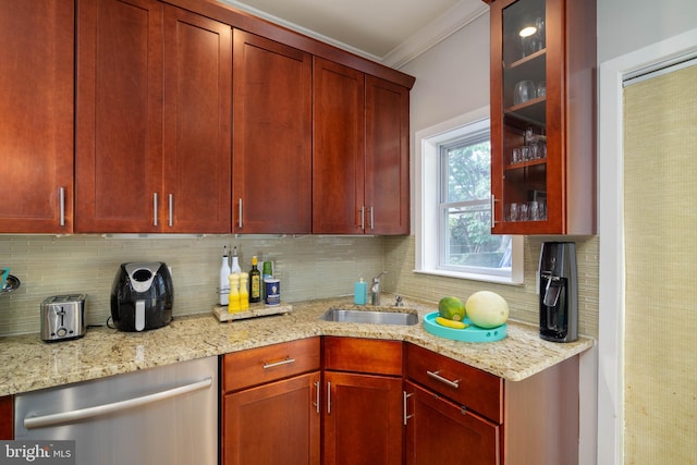 kitchen featuring decorative backsplash, dishwasher, light stone countertops, and sink