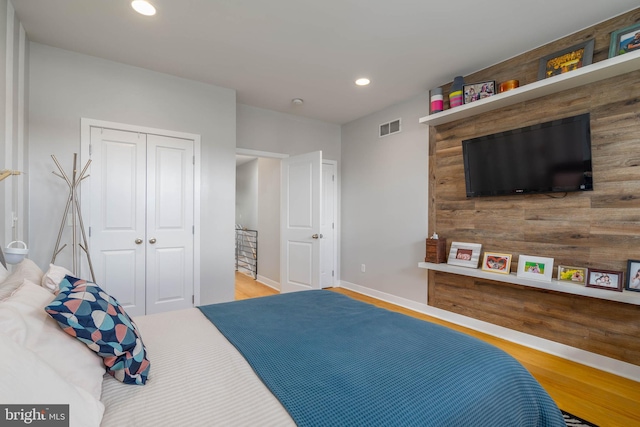 bedroom with light hardwood / wood-style flooring and a closet