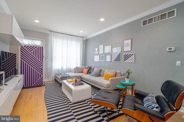 living room featuring crown molding and light hardwood / wood-style flooring