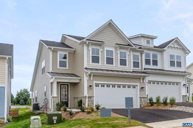 view of front of home with a garage and central AC