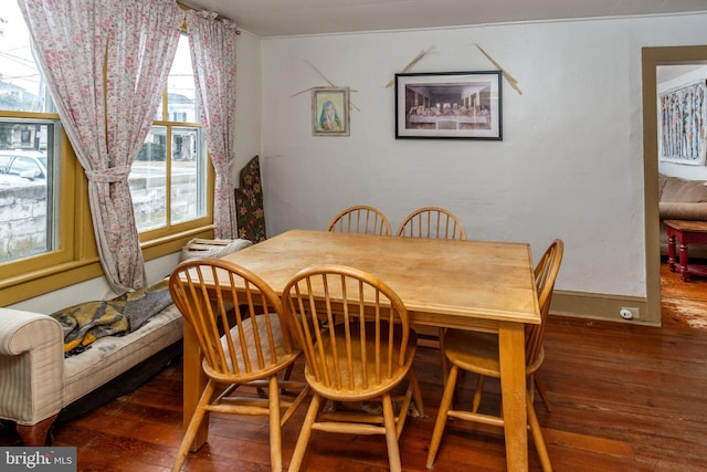 dining space featuring baseboards and wood-type flooring