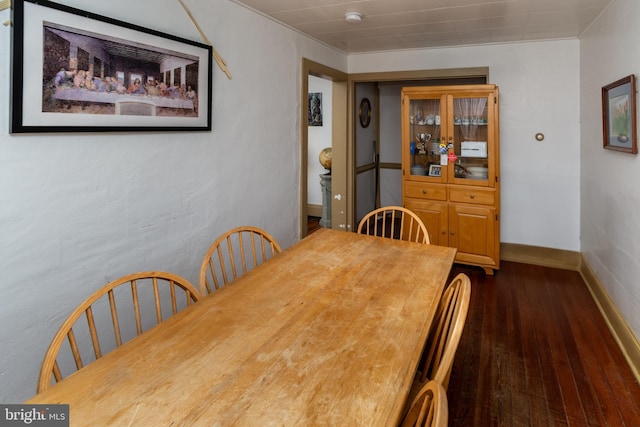 dining area featuring dark wood-type flooring and baseboards