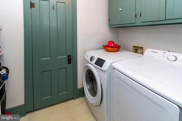 clothes washing area featuring cabinet space, light tile patterned flooring, and washing machine and dryer