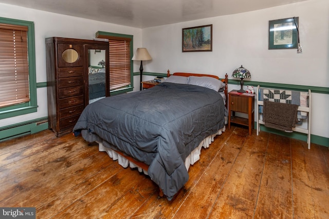 bedroom featuring baseboard heating and hardwood / wood-style flooring