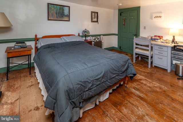 bedroom featuring baseboards and wood-type flooring