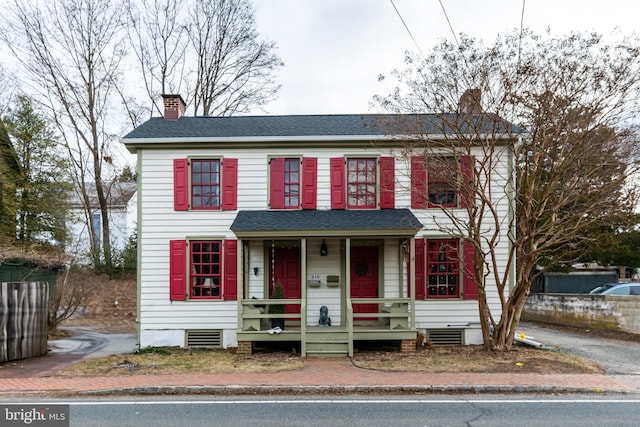 view of front of property featuring crawl space, a porch, a chimney, and a shingled roof