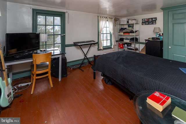 bedroom with wood-type flooring and a baseboard radiator