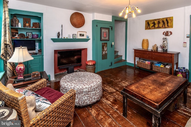 living room featuring a chandelier, a fireplace, dark wood-style flooring, and stairs