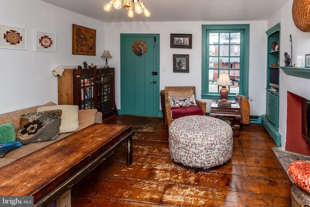 sitting room with a chandelier, a fireplace with flush hearth, a baseboard heating unit, and hardwood / wood-style floors