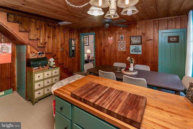 dining area with stairway, wood walls, wooden ceiling, and ceiling fan