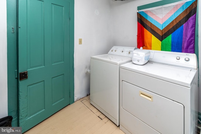 laundry area with light wood-style flooring, laundry area, and washing machine and clothes dryer