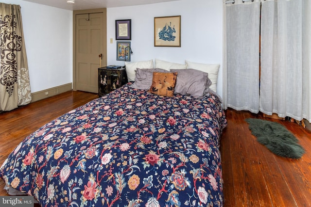 bedroom featuring baseboards and wood finished floors