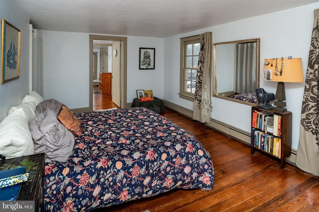 bedroom with hardwood / wood-style floors, baseboards, and a baseboard radiator