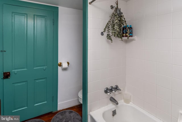 full bathroom featuring toilet, wood finished floors, and shower / bathtub combination