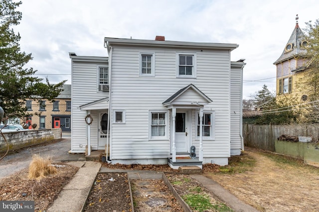 rear view of property featuring fence and a chimney