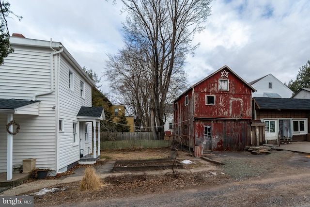 exterior space with a barn, an outdoor structure, and fence