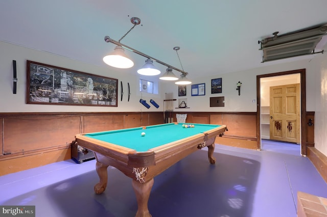 rec room with electric panel, wainscoting, concrete floors, and pool table