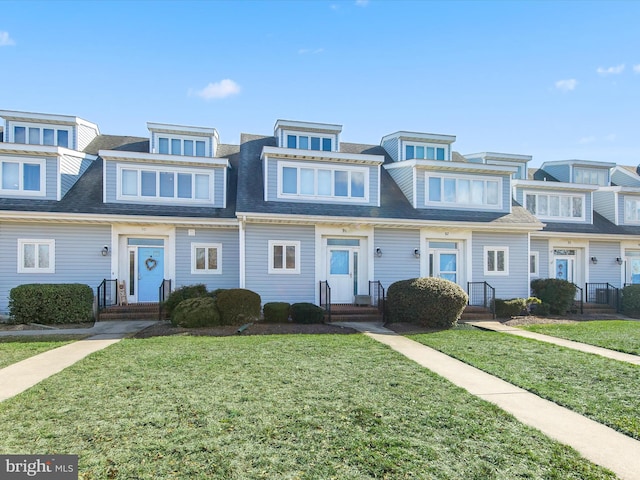 townhome / multi-family property featuring a front lawn