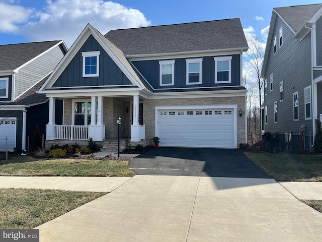 craftsman-style home with a porch, aphalt driveway, an attached garage, roof with shingles, and board and batten siding