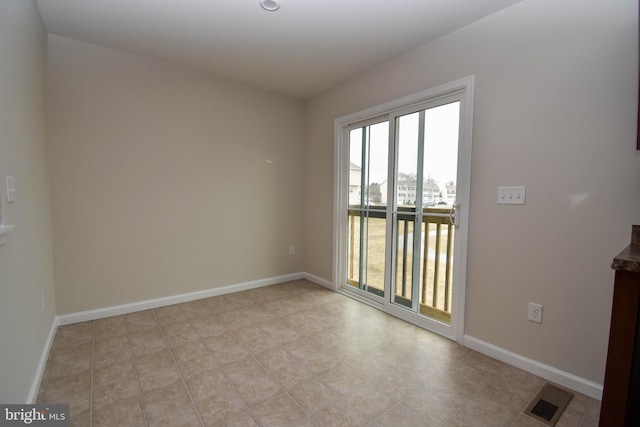 empty room featuring baseboards and visible vents