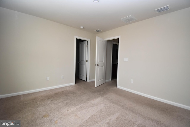 unfurnished room featuring light carpet, baseboards, and visible vents