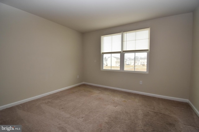 unfurnished room with carpet floors and baseboards