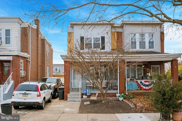 view of front facade with brick siding and a porch