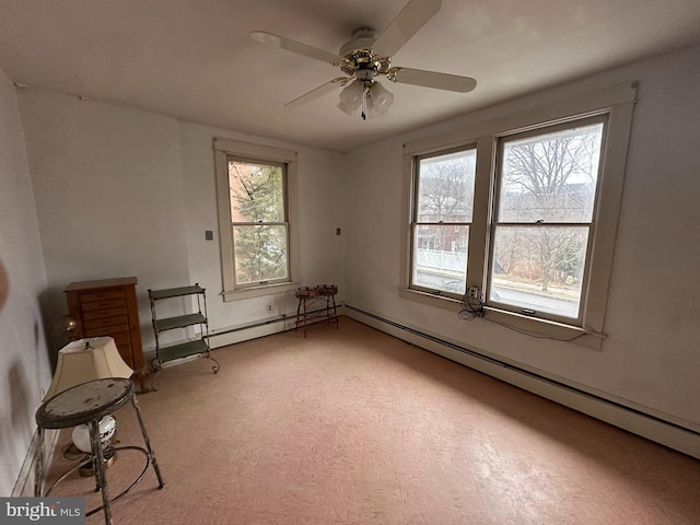 unfurnished room featuring a ceiling fan, a baseboard radiator, and baseboards